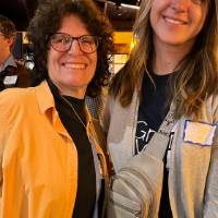 Two alums smiling for a photo together.